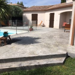 Les deux marches côté jardin et le contour du palmier. La gouttière a été prolongée sous le béton imprimé vers la pelouse. Une pente progressive a été ré-établie et la pose des barrières réussie grâce au travail de préparation !