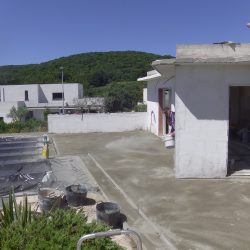 Etape de saupoudrage manuel des durcisseurs colorés à la surface du béton fibré.