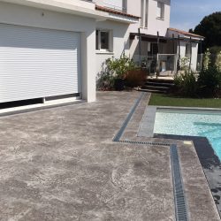 Autre vue de la terrasse terminée. Le caniveau suit les contours de la piscine pour un plus grand esthétisme.